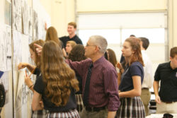 An instructor points to information on the wall