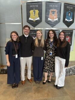 5 people standing in front of posters