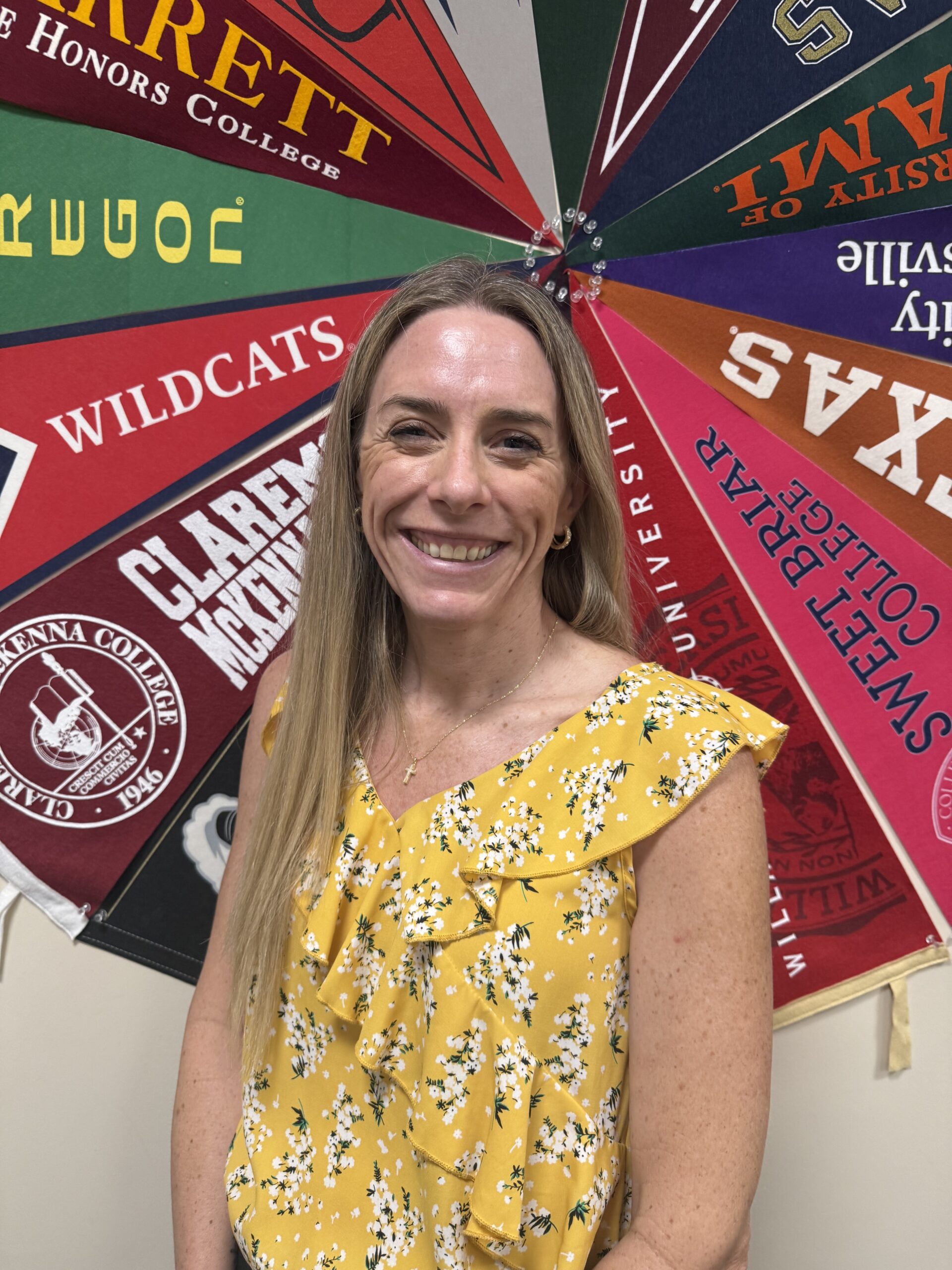 woman standing in front of college flags